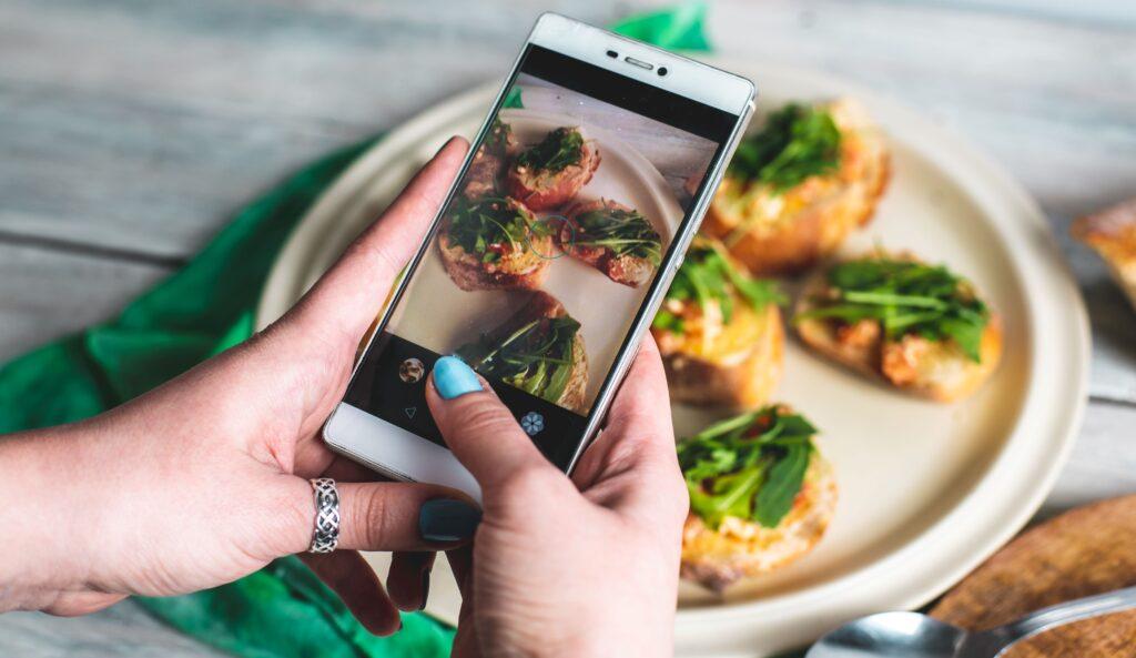 Eine Person macht Fotos mit ihrem Handy und fotografiert gesunde Lebensmittel